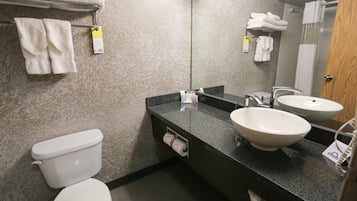 Un baño moderno con inodoro, dos lavamanos, un perchero y un espejo.