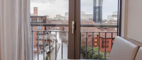Un balcón con sofá y vistas a la ciudad y un río.