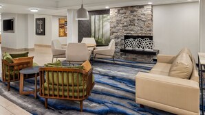 Un salon moderne avec un mur d’accent en pierre, une cheminée et un tapis à motifs bleus.