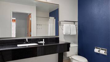Une salle de bain avec un lavabo au comptoir noir, des toilettes blanches et un mur bleu.