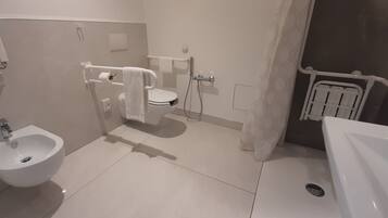 A modern bathroom with a bidet, toilet, and sink.
