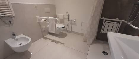 A modern bathroom with a bidet, toilet, and sink.