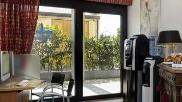 A modern room with a desk, computer, and a coffee machine.