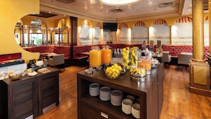 A hotel lobby with a buffet area, seating, and a large mirror reflecting the interior. - Best Western Hotel Tritone (Mestre)