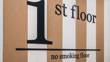 A sign indicating '1st floor' with a 'no smoking' policy.