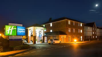 Vista frontal de la propiedad por la tarde o noche