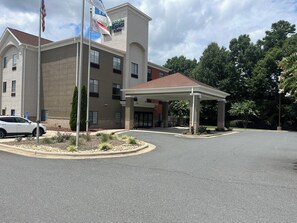 A Holiday Inn Express building with a covered entrance and a parking lot. - Holiday Inn Express & Suites Albermarle by IHG (Albemarle)