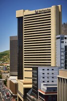 A modern high-rise building with a prominent "Southern Sun" sign, surrounded by other urban structures.