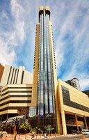 Un edificio alto y moderno con fachada de vidrio y una parte superior curva.