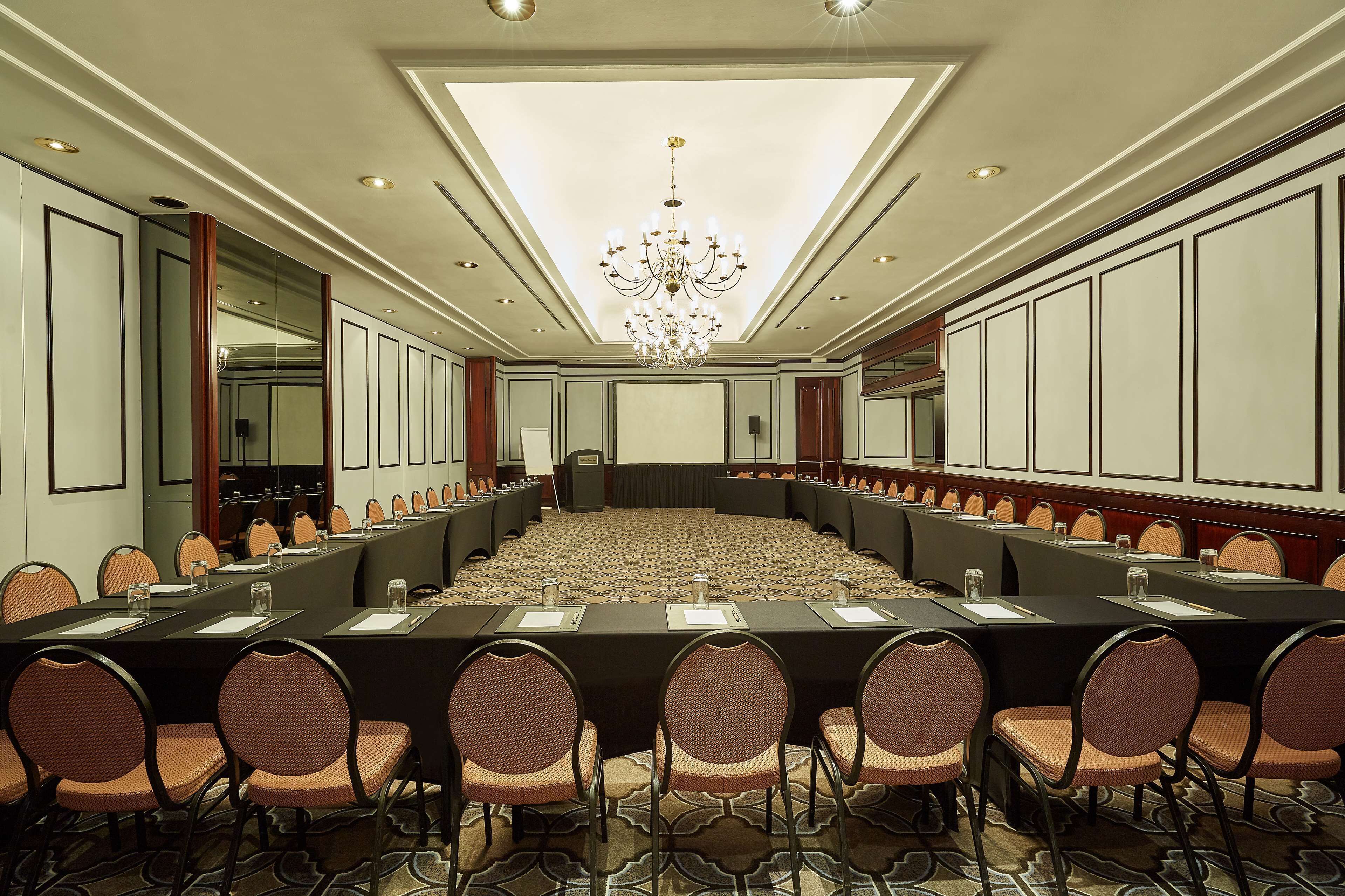 A conference room with a long table, chairs, and a chandelier.
