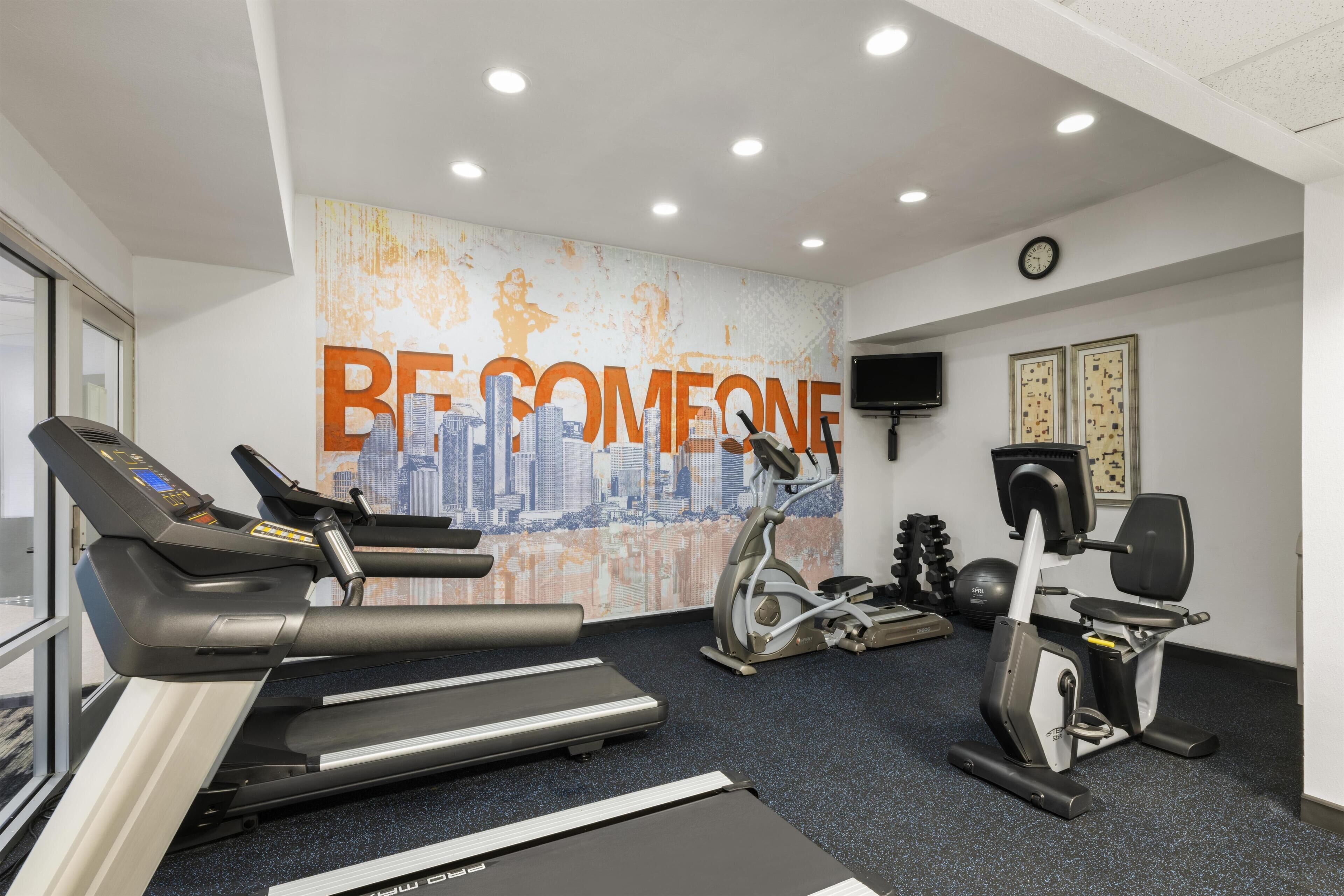 A gym with treadmills, an elliptical, and a stationary bike.