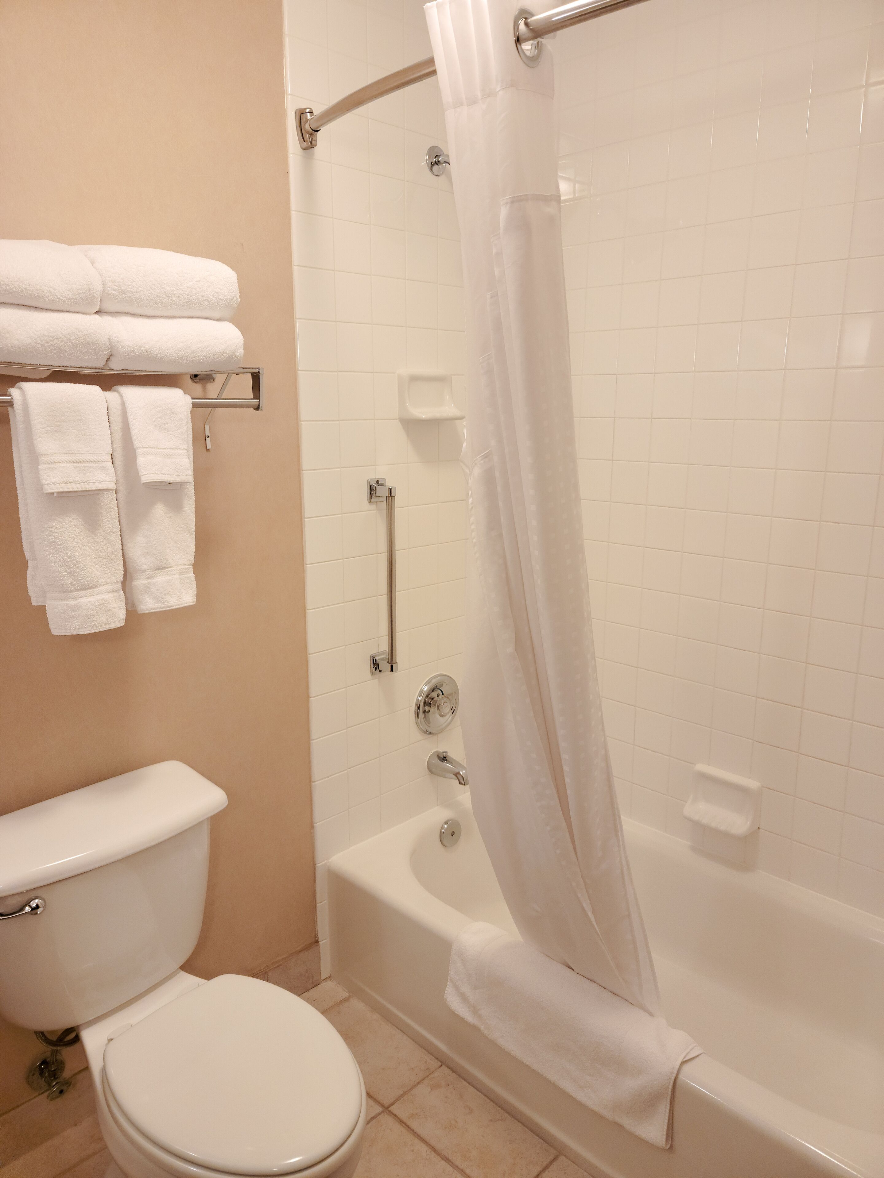 Un baño con inodoro, bañera y cortina de ducha.