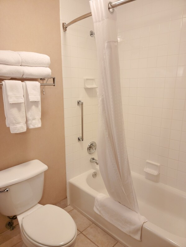 A bathroom with a toilet, a bathtub, and a shower curtain. - Holiday Inn Express Hotel & Suites Portland-NW Downtown by IHG (Portland)