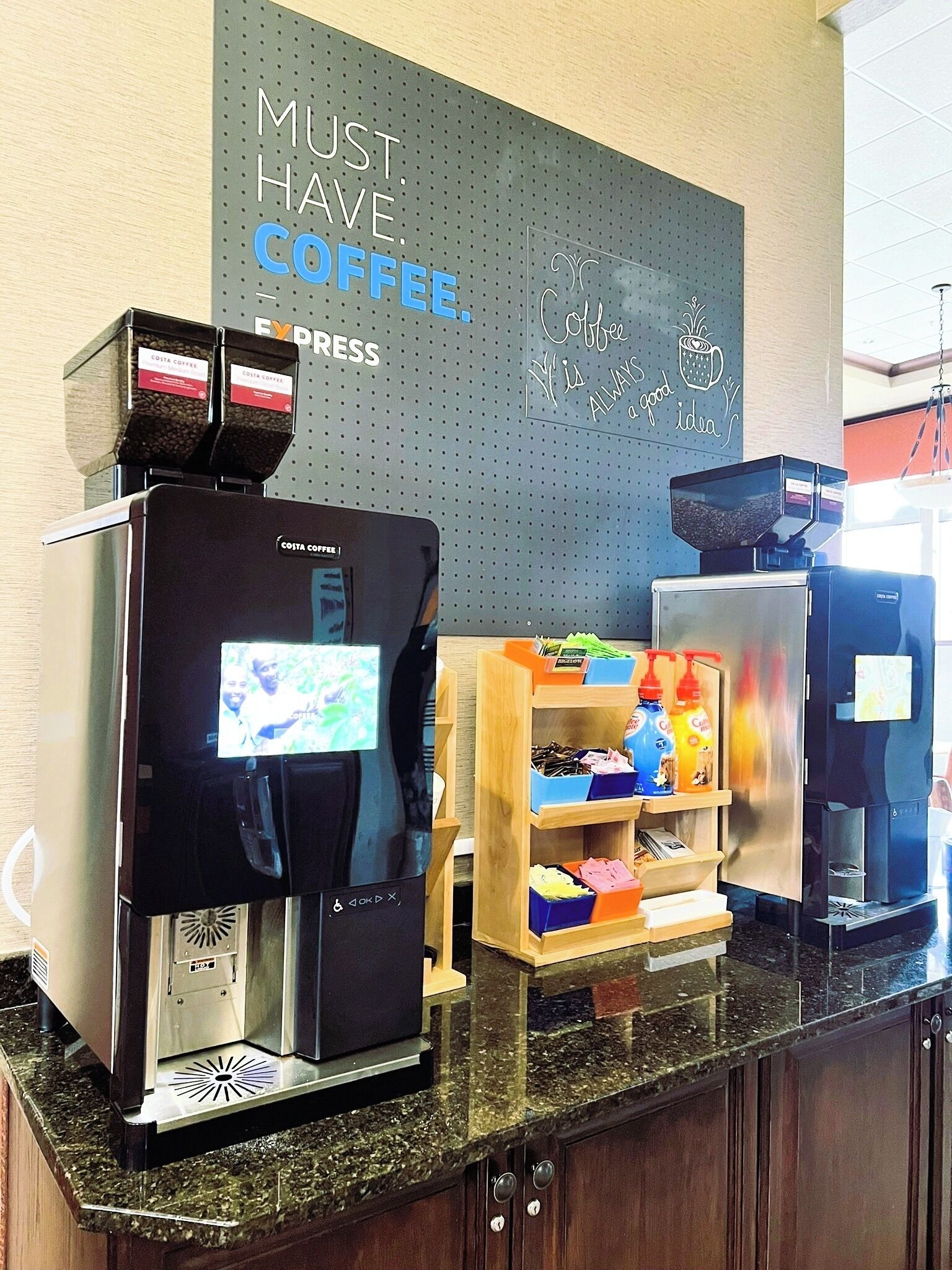 A coffee station with a coffee machine, a coffee dispenser, and a shelf with coffee-related items.