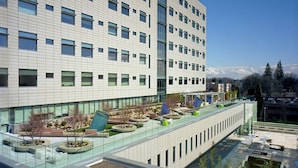 A modern building with a flat roof terrace featuring outdoor seating and planters. - Holiday Inn Express Hotel & Suites Portland-NW Downtown by IHG (Portland)