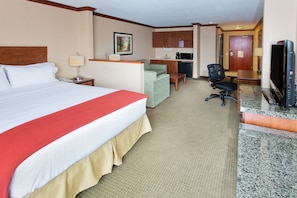 A hotel room with a large bed, a desk, a chair, a television, and a kitchenette. - Holiday Inn Express Hotel & Suites Portland-NW Downtown by IHG (Portland)