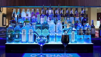 A bar with a variety of liquor bottles and a glass with a straw.