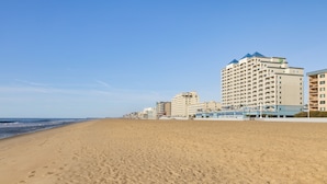 A beach with a row of multi-story hotels. - Holiday Inn & Suites Ocean City by IHG (Ocean City)