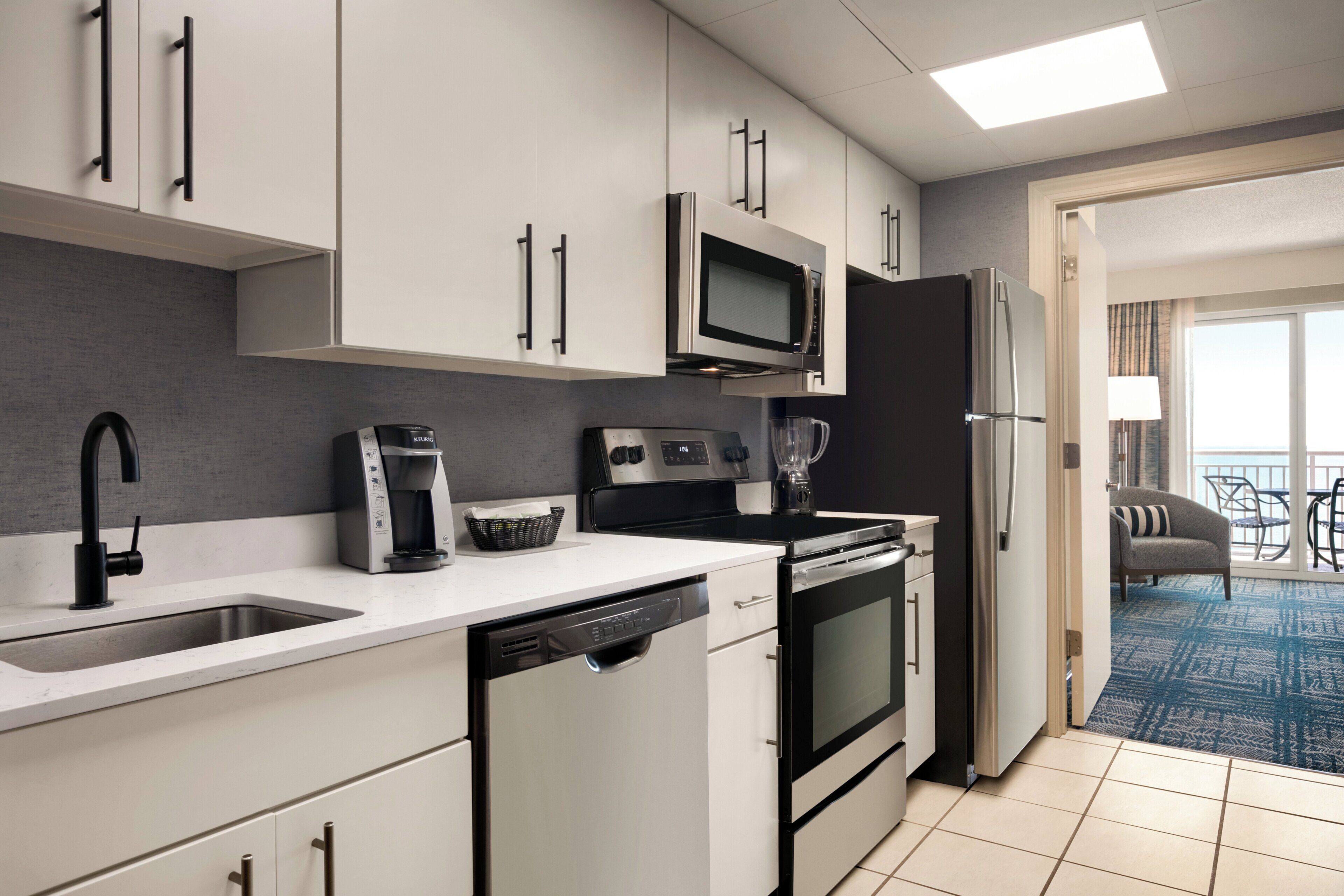 A modern kitchen with a dishwasher, microwave, stove, and refrigerator.