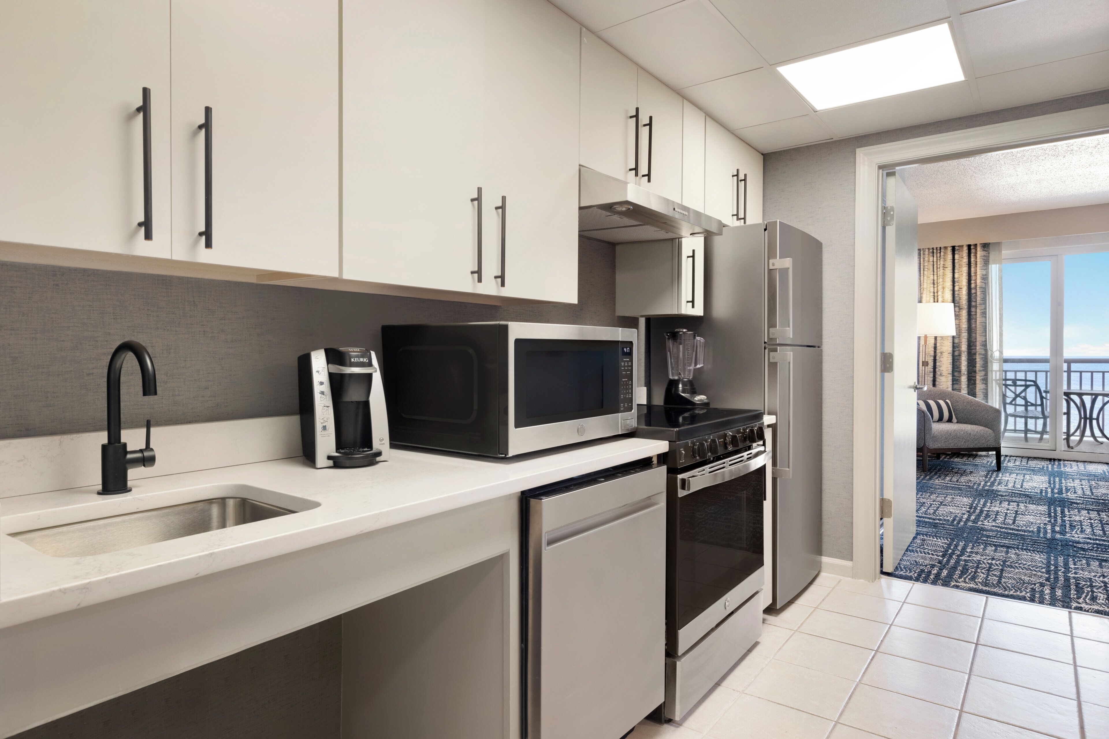 A modern kitchen with a built-in microwave, coffee maker, and oven.