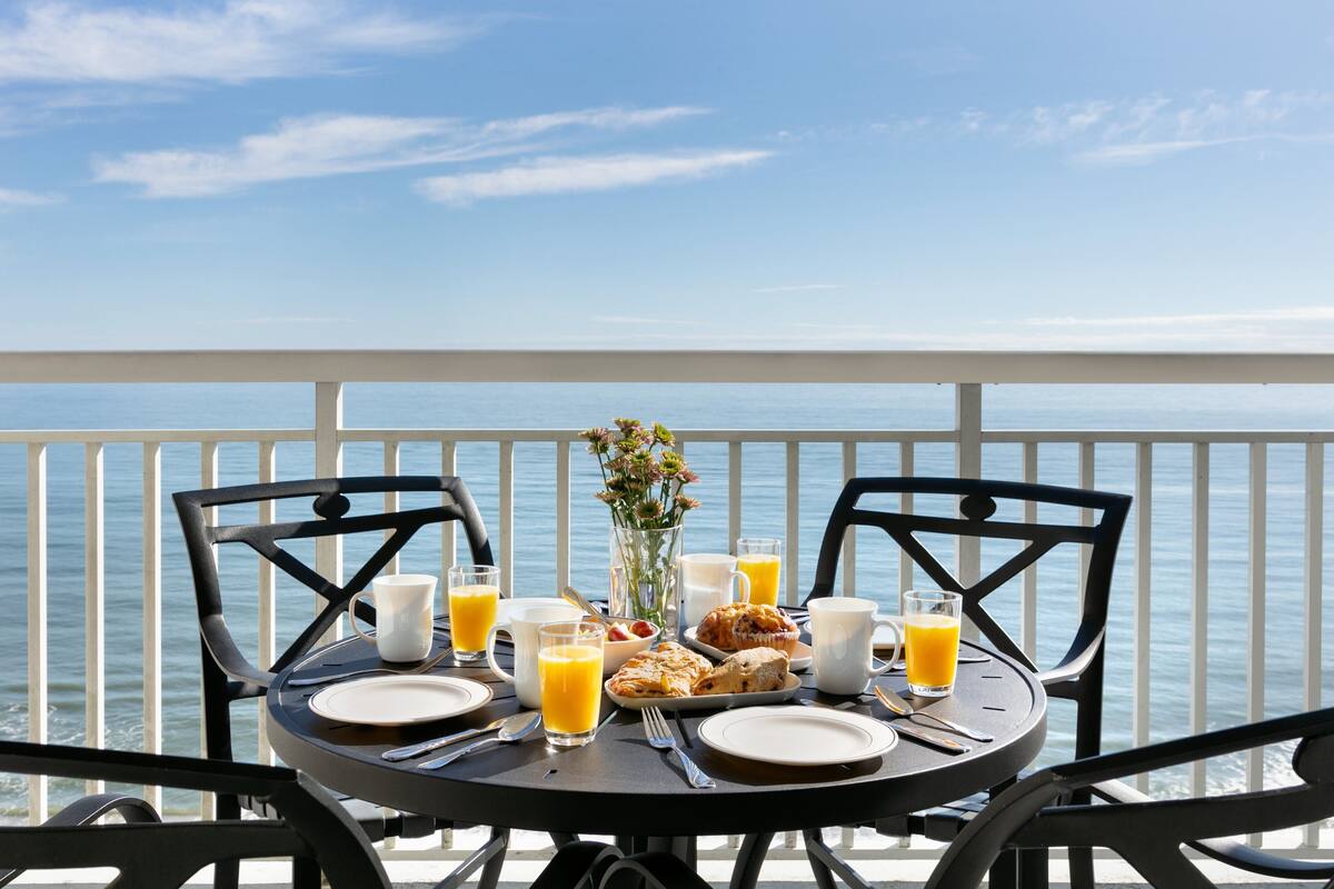A table set for breakfast with a view of the sea.