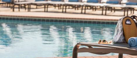 A poolside area with lounge chairs and a sunbed.