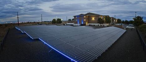 A large solar panel array with a building in the background.