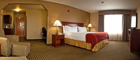 A hotel room with a bed, two bedside lamps, a desk with a telephone, a chair, and a television.