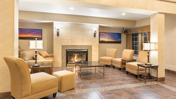 A hotel lobby with a fireplace, comfortable seating, and artwork on the walls.