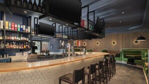 A bar area with a counter, stools, and shelves of bottles.