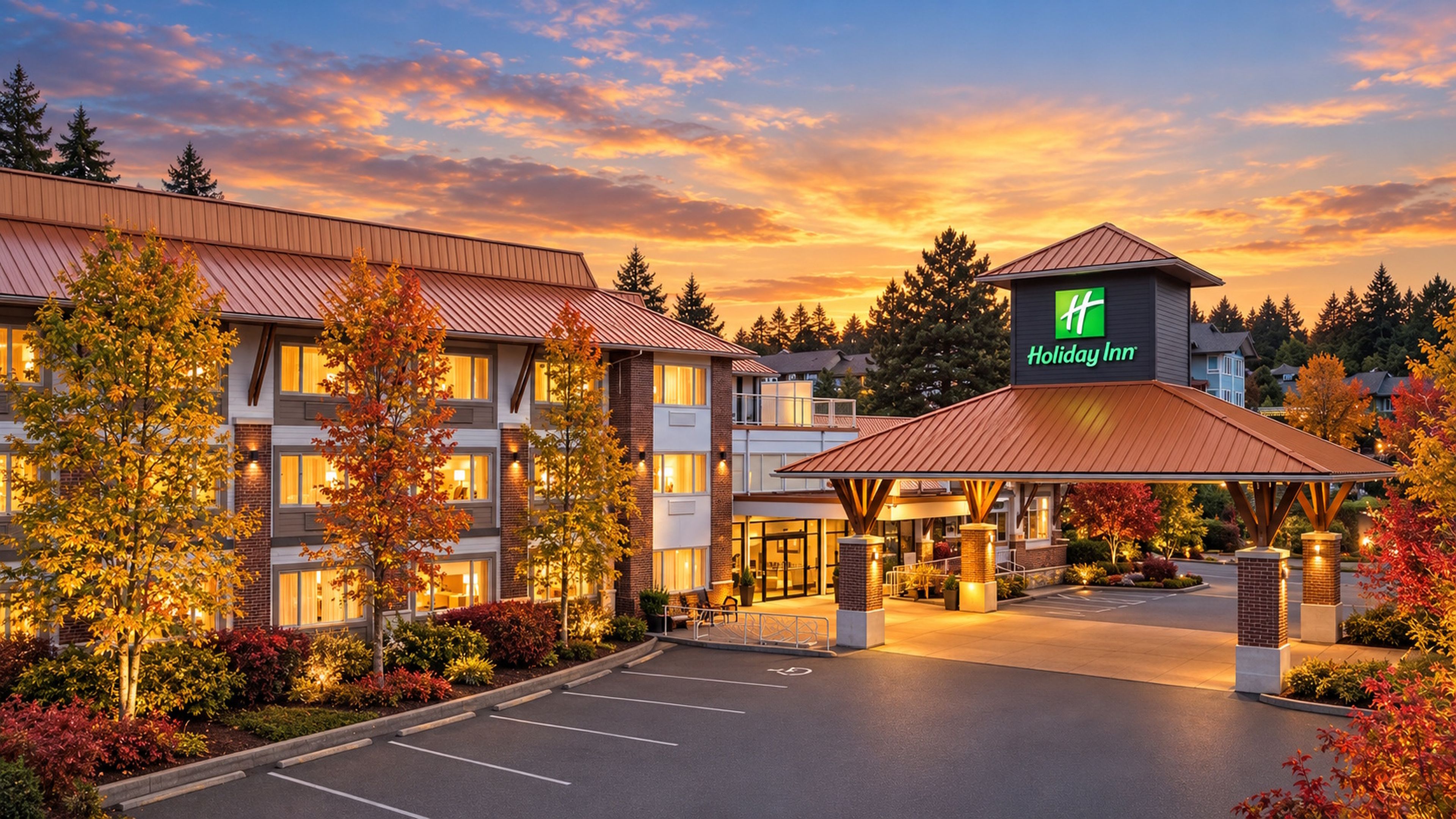 Ein Holiday Inn Hotel mit überdachter Eingangsparte, Parkplatz und Herbstlaub.