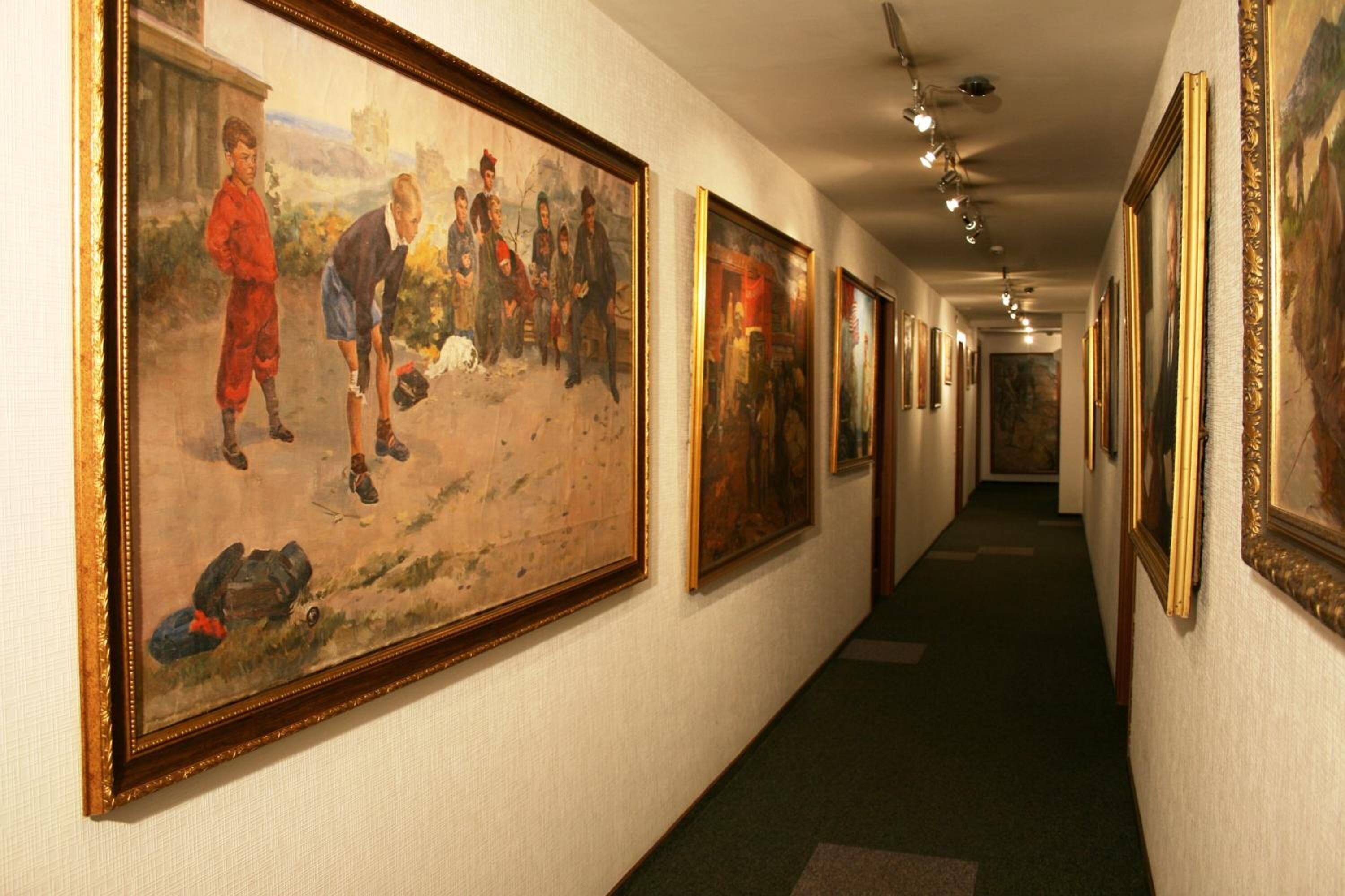 Um corredor com várias pinturas emolduradas nas paredes.
