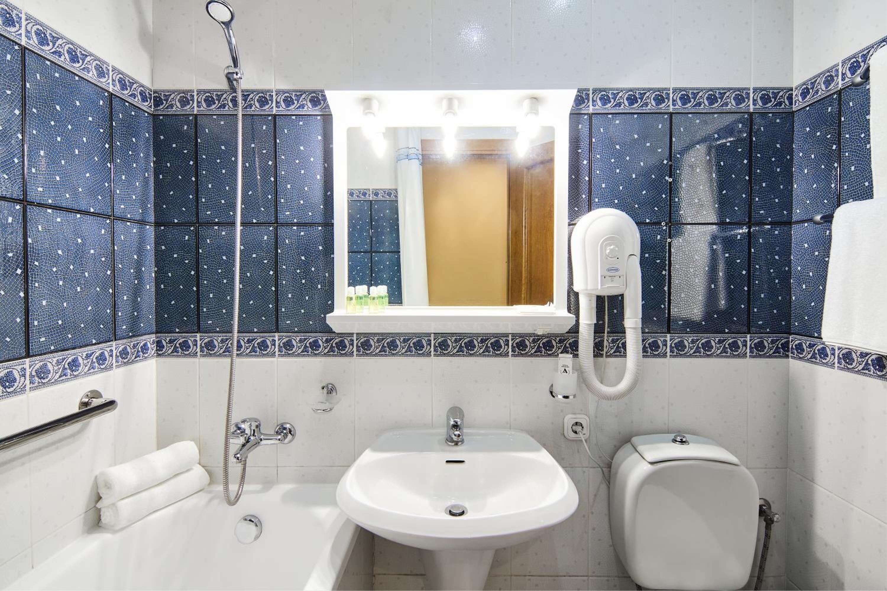 A bathroom with a white sink, a toilet, and a shower.