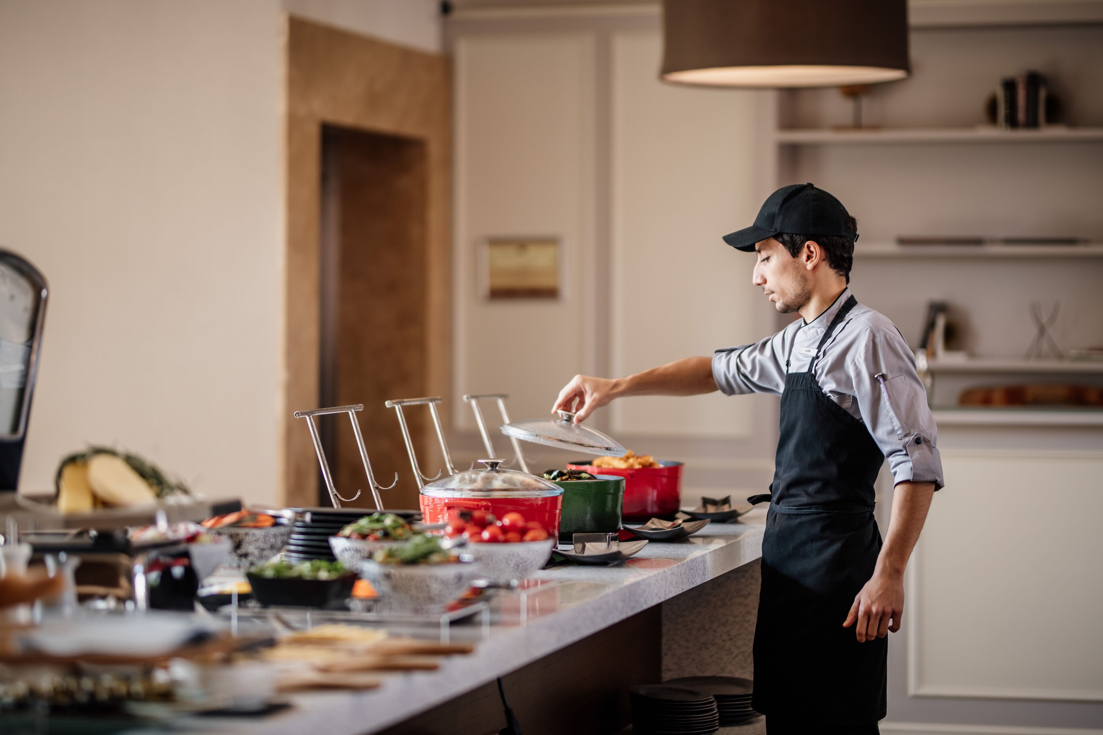 Un buffet proposant une variété de plats et une personne qui sert les clients.