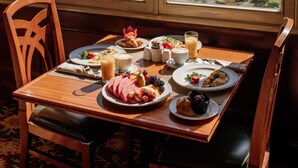 A dining table with breakfast items and a view of a cityscape through large windows. - Armenia Marriott Hotel Yerevan (Yerevan)