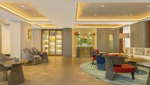 A modern hotel lobby with a reception desk, seating area, and a plant display. - Armenia Marriott Hotel Yerevan (Yerevan)