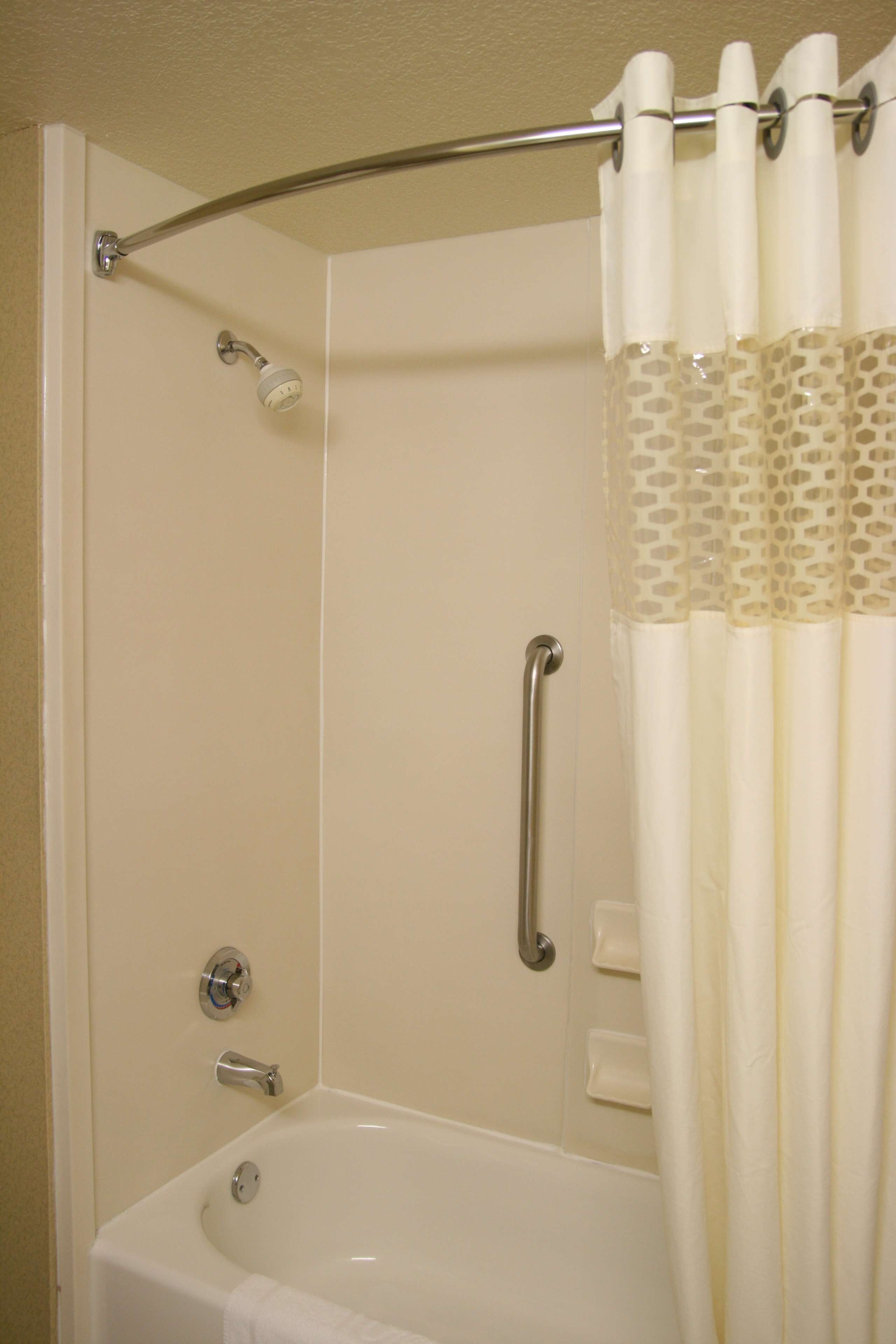 A shower area with a bathtub, a showerhead, and a curtain.