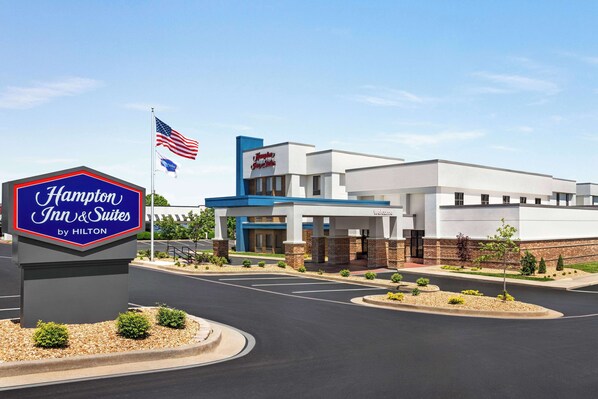 A Hampton Inn & Suites by Hilton with a modern design, a welcoming entrance, and a landscaped area in front.