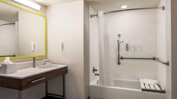 A modern bathroom with a sink, mirror, and shower.