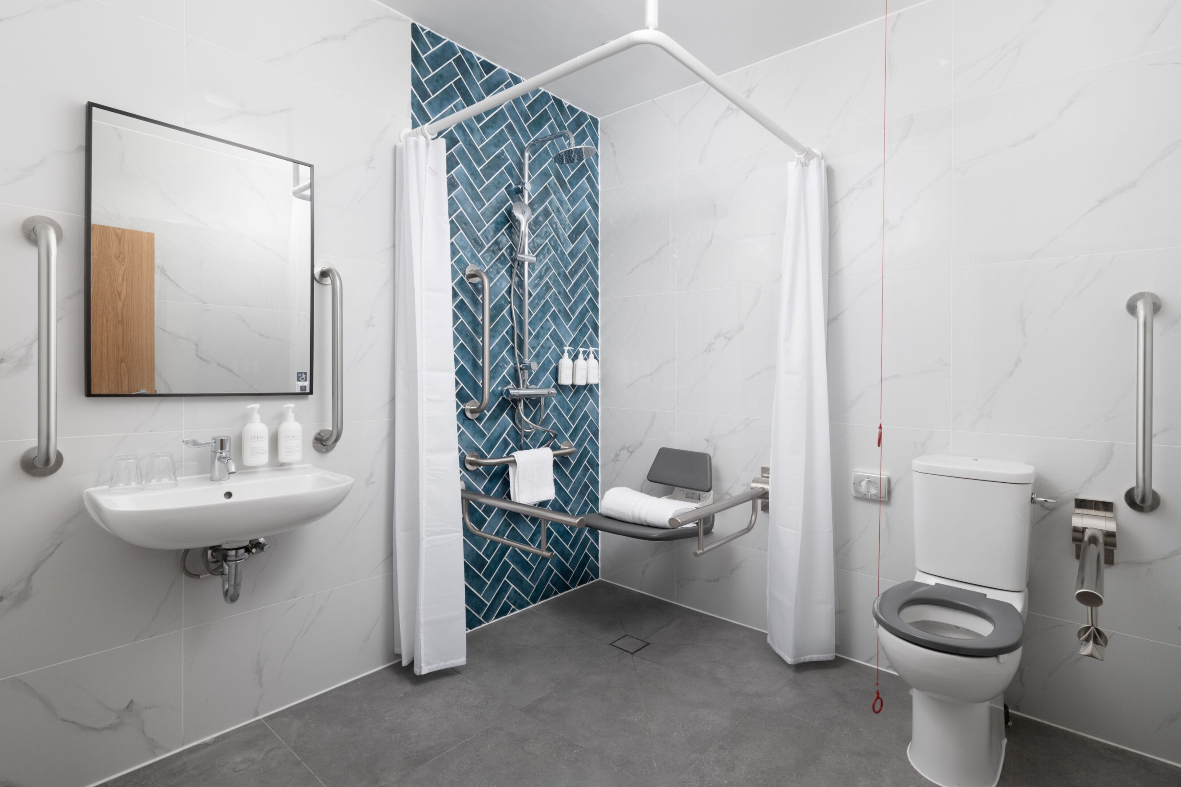 Et moderne badeværelse med brusebad, toilet og håndvask.