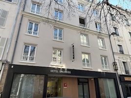Un edificio de hotel con varias ventanas y un letrero que dice "HOTEL ORCHIDEE".