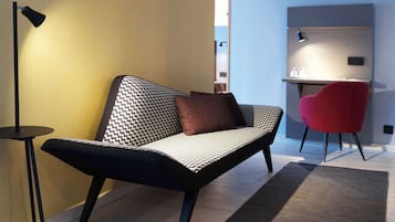Un espacio moderno para vivir con un sofá, una silla roja y un escritorio.