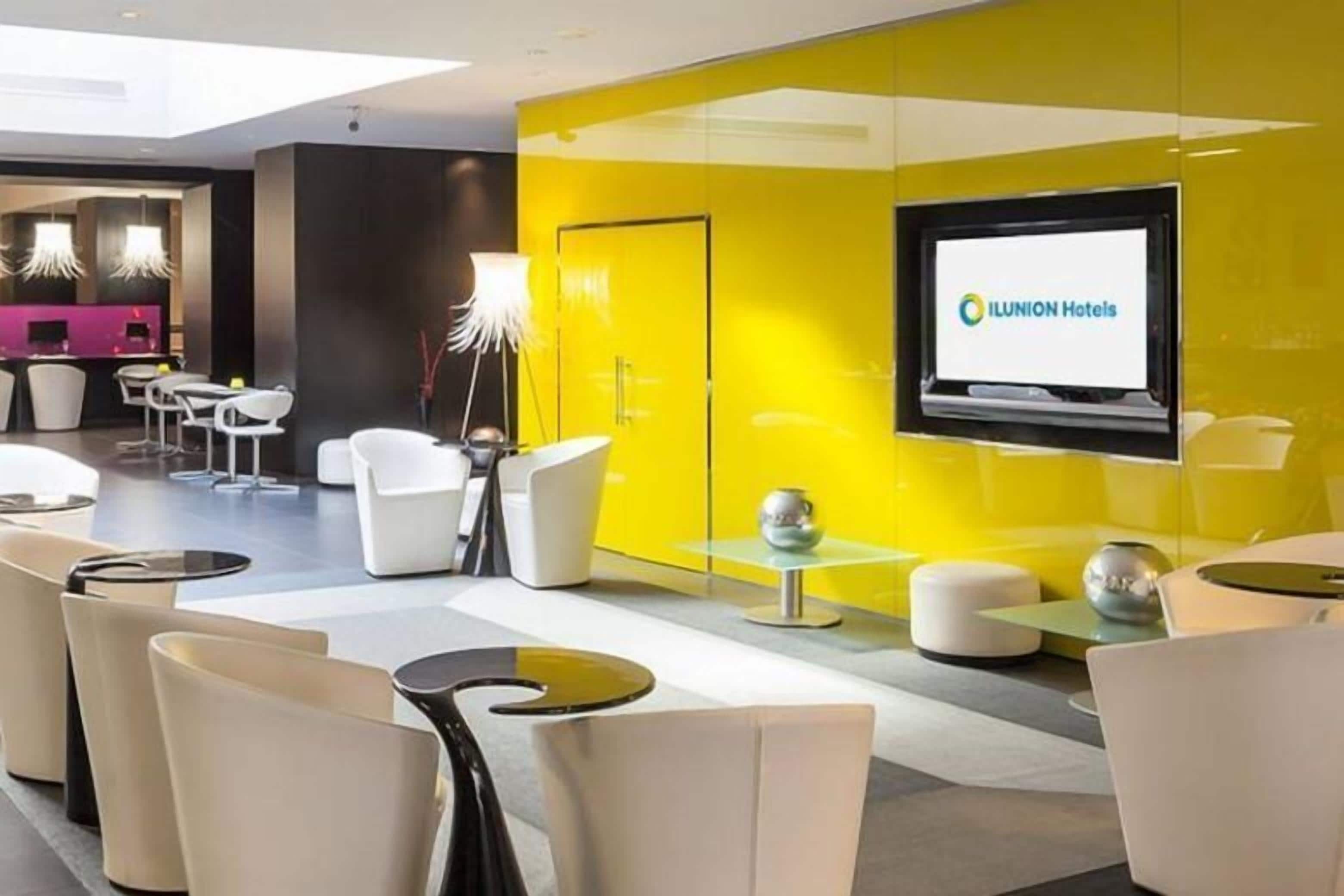 En moderne hotellobby med en lys gul farveaccent, en receptionsdisk og moderne siddepladser.