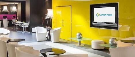 En moderne hotellobby med en lys gul farveaccent, en receptionsdisk og moderne siddepladser.