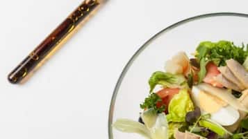 A clear view of a salad bowl with various ingredients, a knife, and a glass plate.