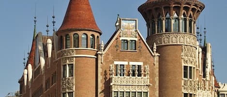 Ein historisches Gebäude mit zwei markanten Türmen, einer mit einem Kegeldach und der andere mit einer Turmspitze.