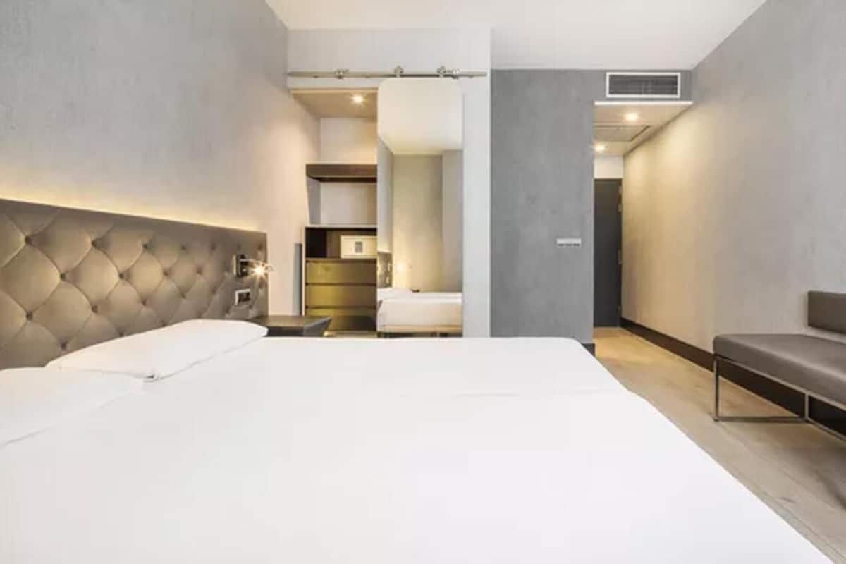 Et moderne hotelværelse med en stor seng, en sofa og et indbygget skab.