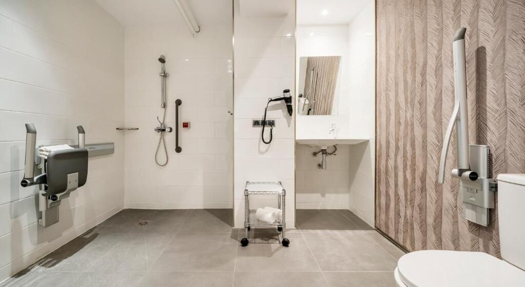 A modern bathroom with a shower, toilet, and sink.