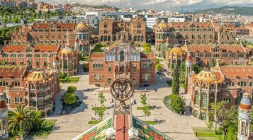 A large, ornate building with a central courtyard and multiple smaller structures around it.