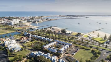 A coastal resort with multiple buildings, a marina, and a beach.